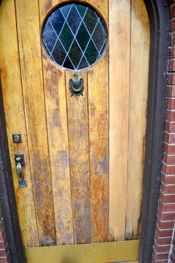 Sanding off a worn finish on wood front door