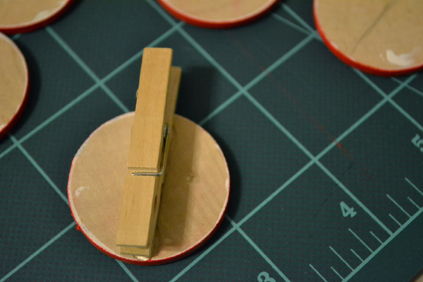 Glue clothespins to back of wooden nickels