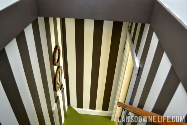 Stairway makeover reveal with green painted stairs and black and white wall stripes