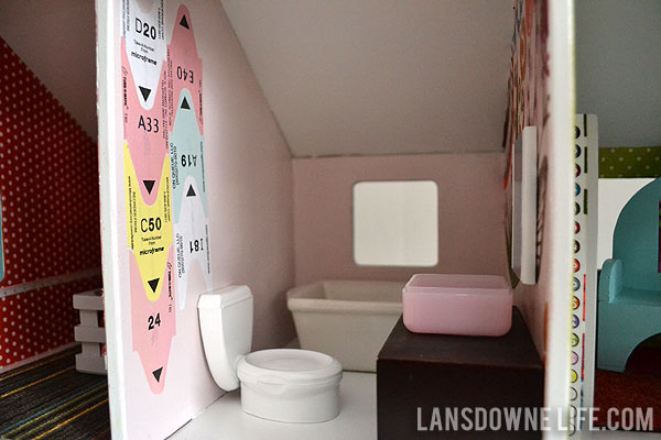 Handmade dollhouse bathroom with toilet, tub, and vanity